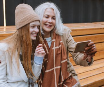 Happy grandmother and teenage girl taking a selfie outdoors