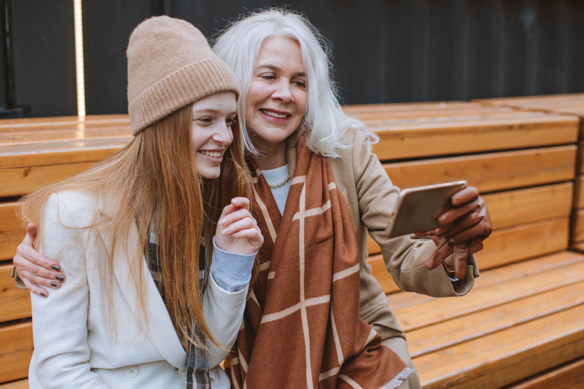Happy grandmother and teenage girl taking a selfie outdoors
