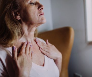 mature woman gently massaging moisturizer into her neck