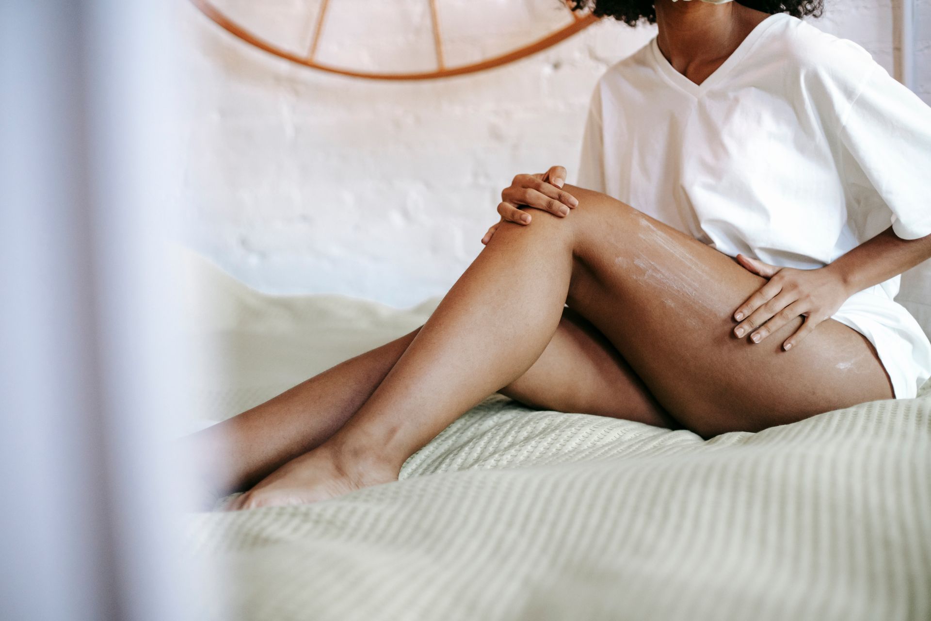 Woman apply skin tightening lotion in a bedroom